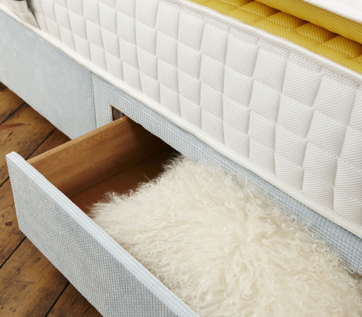 CNC-cut wooden storage drawer built into a divan base