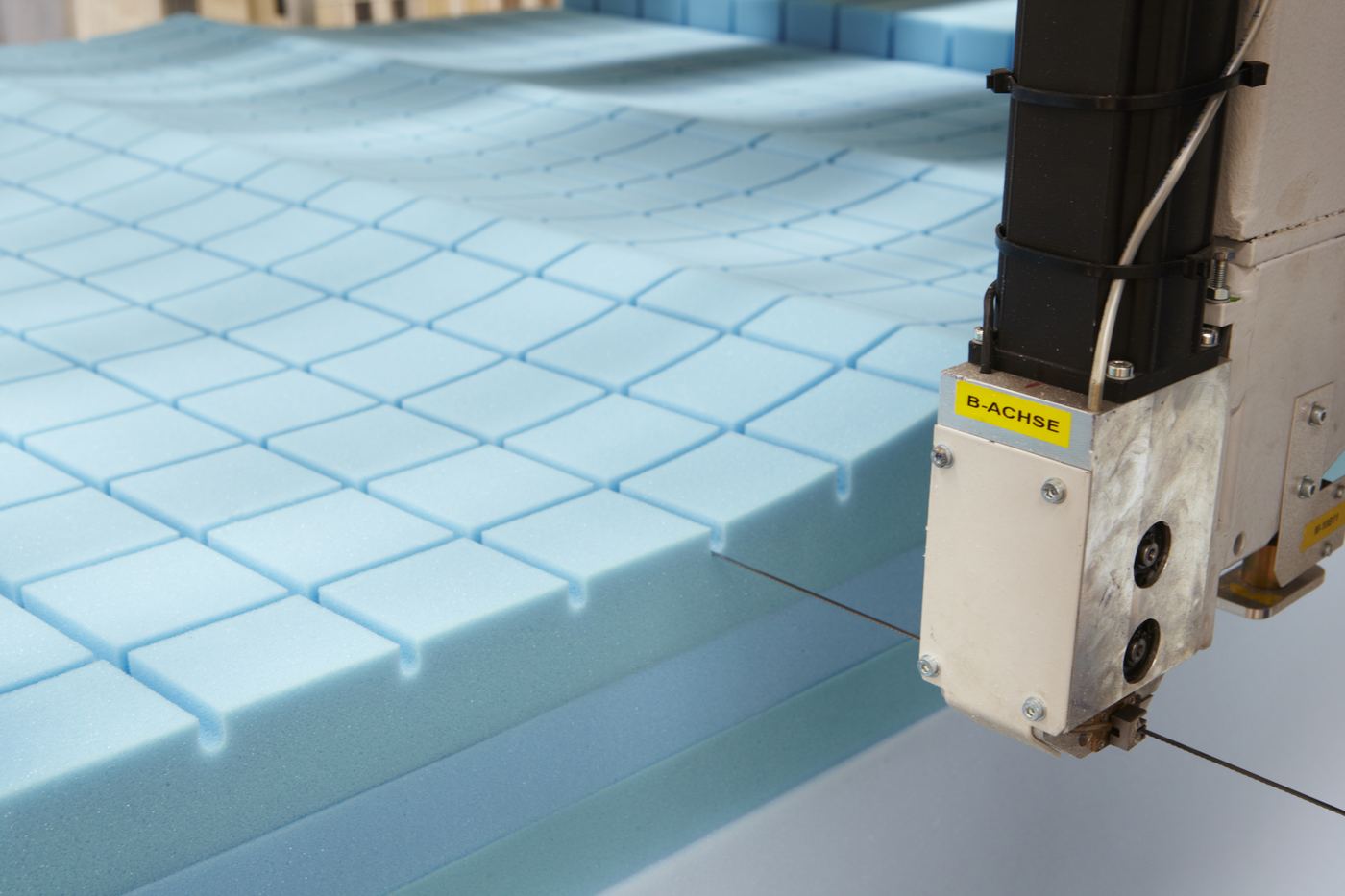 CNC machine cutting foam at Contract Bed Co.'s UK factory