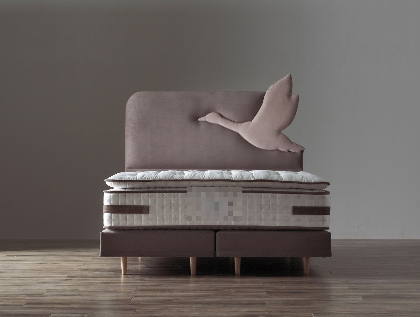 Studio product photo of a Royal Bohemia dusty pink headboard with a flying goose applique design