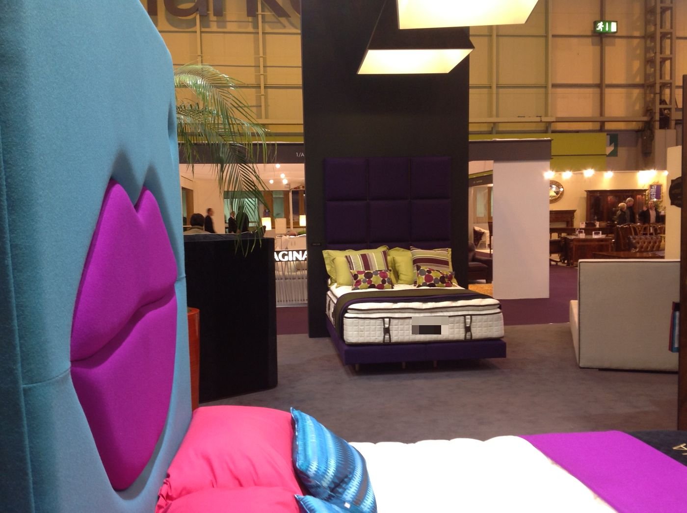 Royal Bohemia showroom display of a red button-tufted headboard with white bedding