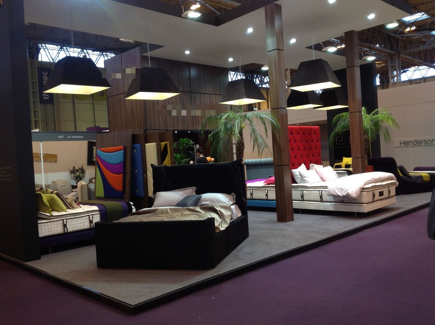 Royal Bohemia trade show booth with mattresses and headboards mounted overhead as a ceiling display