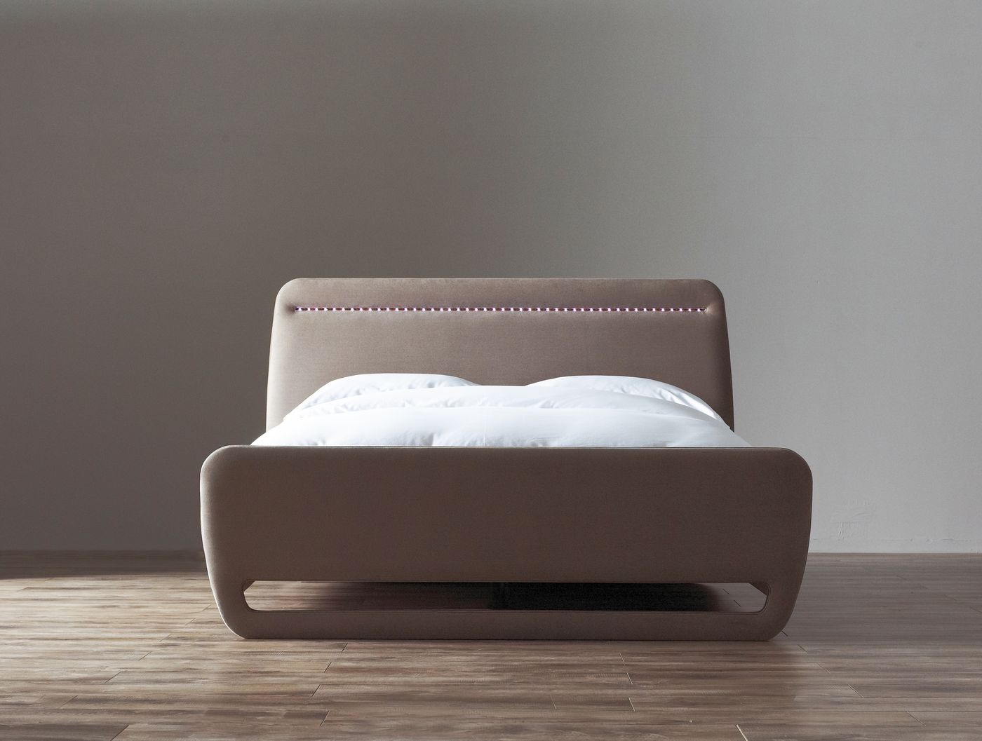 Studio product photo of a taupe upholstered bed frame with a lit LED strip along the headboard seam