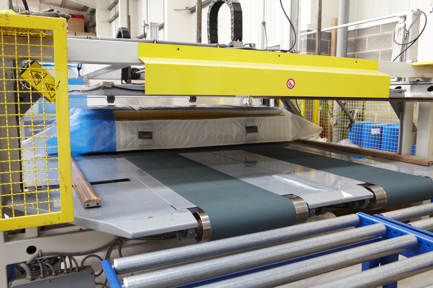 Mattress being compressed and roll-packed for delivery